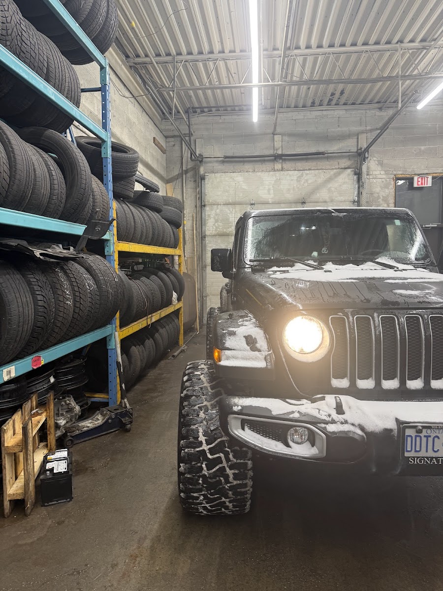 Wall of tires next to a Jeep being serviced